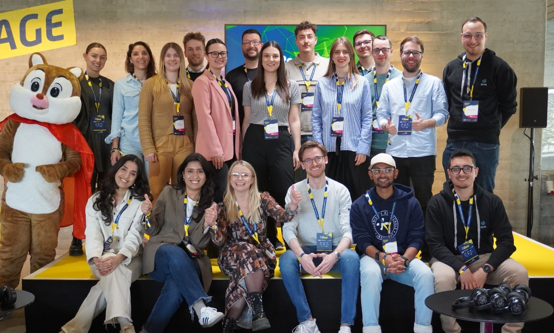Gruppe von Personen stehen für ein Teamfoto auf einer Bühne zusammen