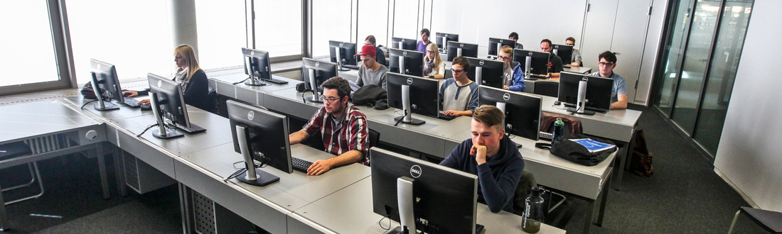 Einige Studenten sitzen im PC Pool der Bibliothek