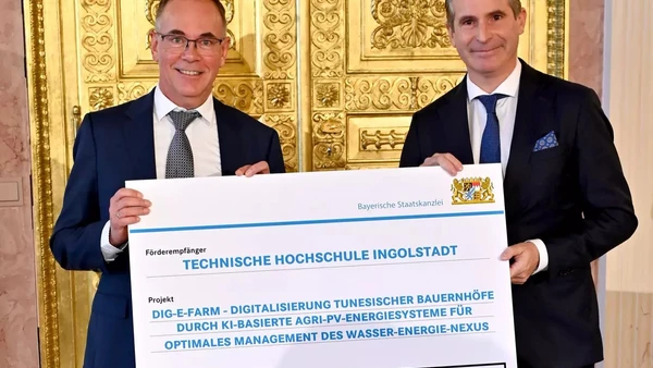 Zwei Männer bei Entgegennahme eines Förderschecks