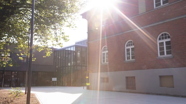 Symboldbild vom Campus mit strahlender Sonne am Himmel